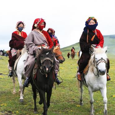 Voyage au Tibet circuit Minya : femmes en tenue traditionnelles sur des chevaux Akaoka