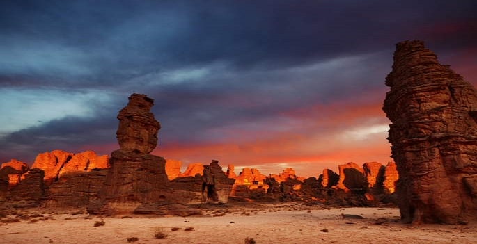 Randonnée chamelière en Algérie sous un coucher de soleil dans le désert Tassili Akaoka
